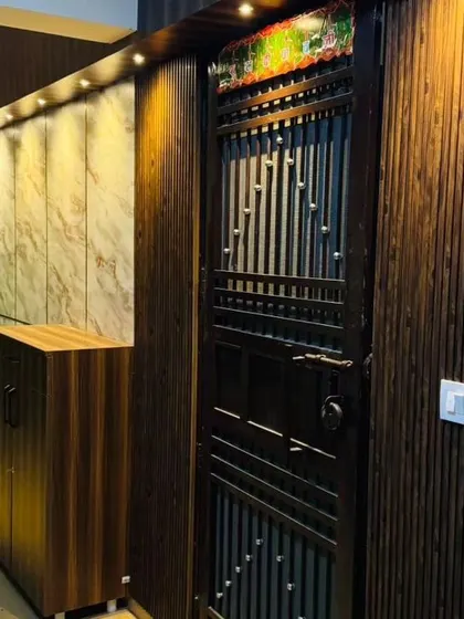 This wider view shows the complete entrance design, including a shoe rack with seating and marble-finish wall panels, combining style with everyday practicality.