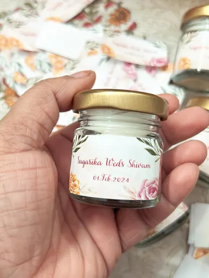 These mini jar candles for Sagarika and Shivam's wedding are simple, elegant, and perfect for bulk orders. The custom floral label adds a personal touch to this classic return gift.