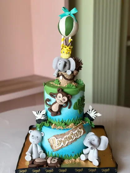 Welcome to the wild side! This jungle-themed cake is roaring with flavor, featuring adorable, handcrafted fondant animals like elephants, monkeys, and lions, perfect for a little explorer's party.