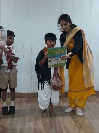 Teachers guide students during their presentation, helping them honor the legacy of the great social reformer Kanakadasa.