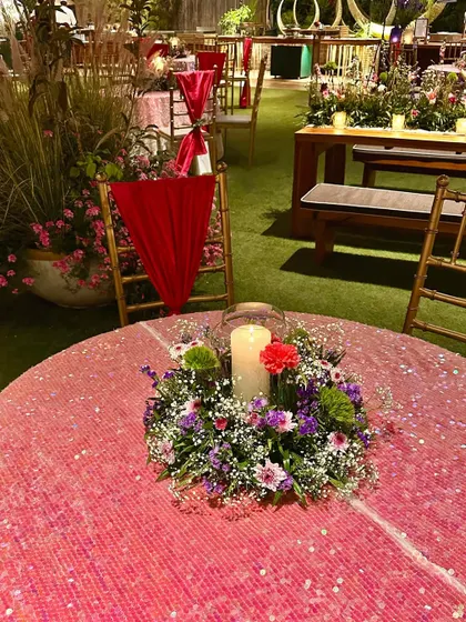 A close-up of a sequined pink tablecloth and a simple candle centerpiece, adding a touch of glamour.