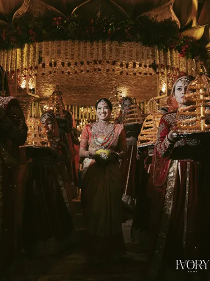 The bride's grand entrance at her South Indian wedding, surrounded by attendants carrying traditional lamps, creating a divine and spectacular visual.