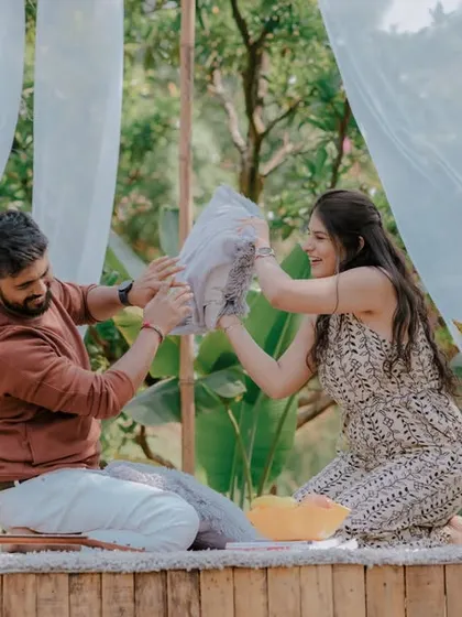 A playful pillow fight during a picnic-style pre-wedding shoot. This fun and energetic activity brings out genuine laughter and creates dynamic, memorable photos that show the couple's lighthearted connection.