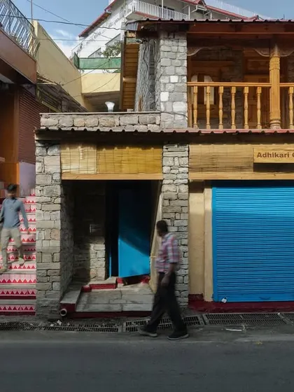 A view of the building's entrance staircase and restored shopfronts, showing how the project revitalized the entire streetscape.