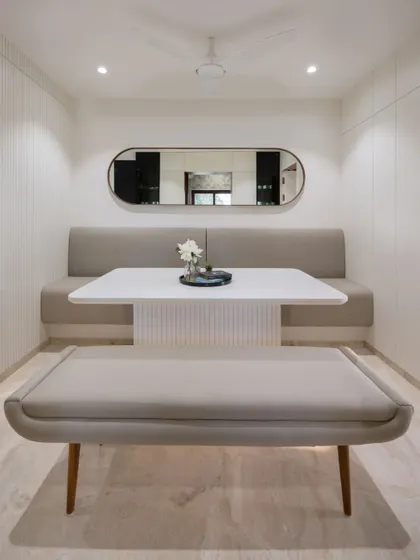 To save space, we designed a custom dining area with bench seating against the wall. The long mirror makes the narrow space feel wider and brighter.