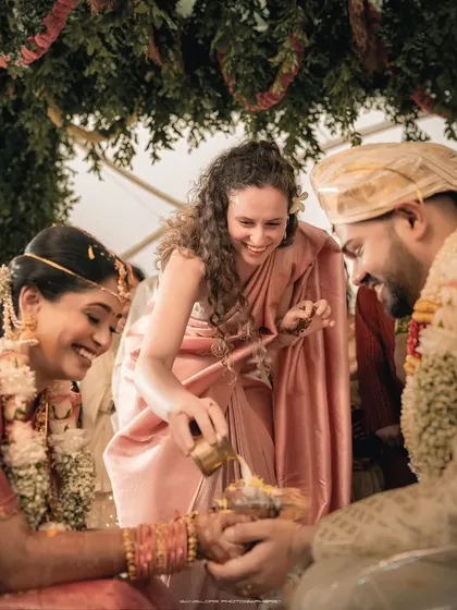 A guest participates in a wedding ritual, her smile adding to the happy atmosphere. I make sure to capture the involvement and joy of family and friends.