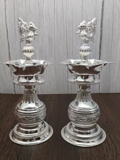 Another design of the German silver Nakashi deepam pair, with a slightly different base and peacock carving.