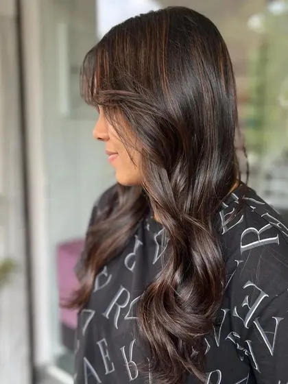 A side view of the client, capturing the movement of her freshly styled hair.