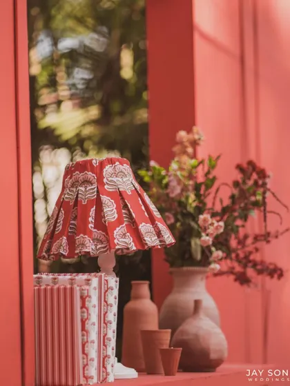 A decorative vignette on a shelf, with a block-printed lampshade, terracotta pots, and other curated items that enhance the event's theme.
