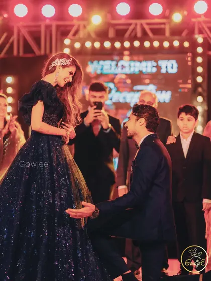 A romantic moment on stage as the groom gets down on one knee for his bride.