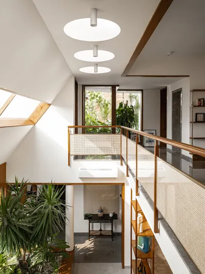 These images show the upper-level bridge and hallway, illuminated by both angled and circular skylights. The combination of different light sources ensures the core of the home is always bright and connected to the time of day.