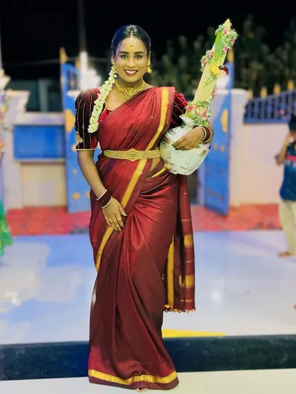 A full view of the traditional maroon saree and velvet blouse, perfect for festive rituals.