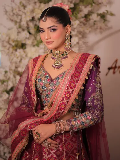 A close-up of the multi-colored silk lehenga. The combination of purple, maroon, and blue embroidery creates a vibrant and festive look.
