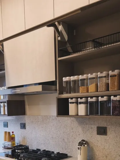 An overview of a modern, organized kitchen. Open shelving with decanted items and clear counters creates a sense of calm and efficiency.