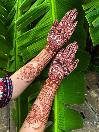 Another angle of the rich henna stain against a backdrop of lush green banana leaves, highlighting the natural, organic quality of my work.