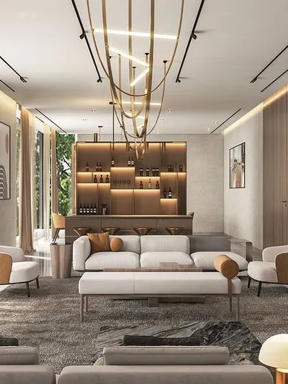 The living and entertainment area in the Jammu residence is designed for modern luxury. It features a stylish bar, comfortable lounge seating, and dramatic lighting, all while maintaining a connection to the outdoors through large glass doors.