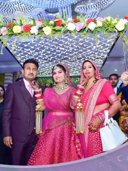 The bride enters with her parents under a floral canopy, a touching family moment we document.