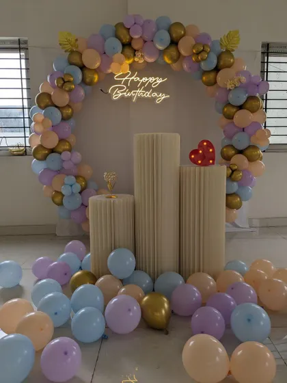 Another angle of the pastel and gold circular balloon arch, showing the loose balloons on the floor that add to the festive atmosphere.