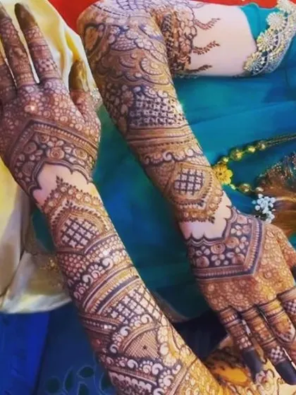 A gorgeous V-shaped design on the back of the hands, creating a slimming and elegant effect. The pattern is dense with traditional motifs and extends beautifully up the arms.