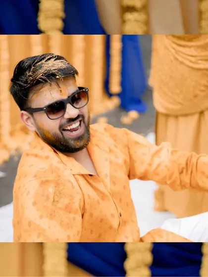 A candid shot of the groom, Akshat, laughing as he gets covered in Haldi, capturing the fun-loving spirit of the event.