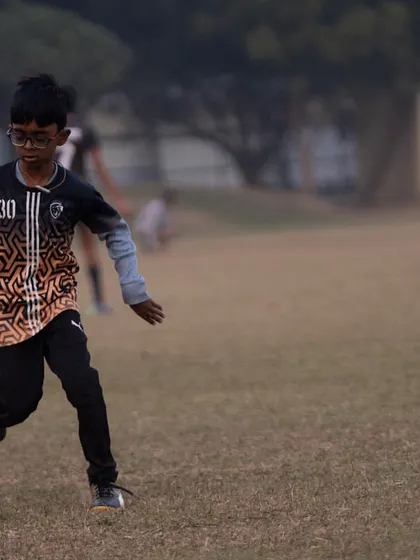 A young player dribbling the ball, focused and determined.