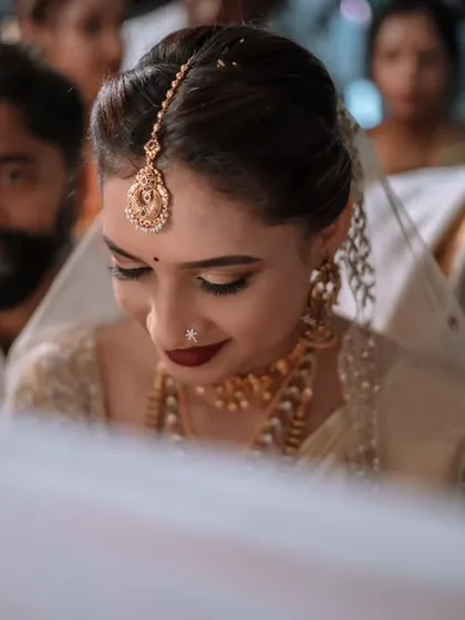 A bride's serene expression during a quiet moment in the ceremony. The focus is on her inner peace and the significance of the rituals taking place.