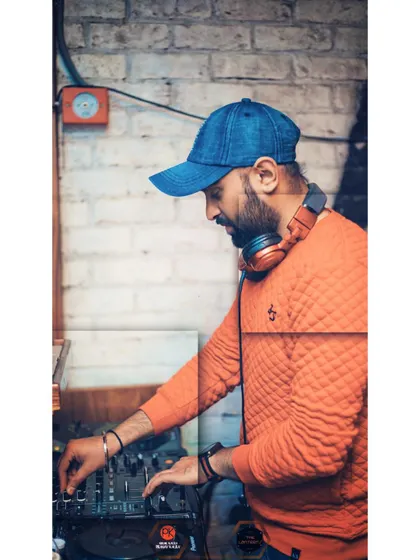A profile shot of me working the mixer in a venue with a rustic brick background. Every gig has a unique atmosphere, and I tailor my set to match it.