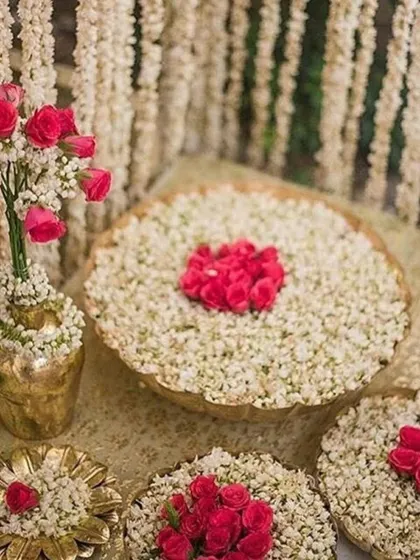 Traditional floral decorations using jasmine and rose petals. This type of intricate floral art, often placed in water-filled urlis, adds a beautiful and fragrant element to any celebration.