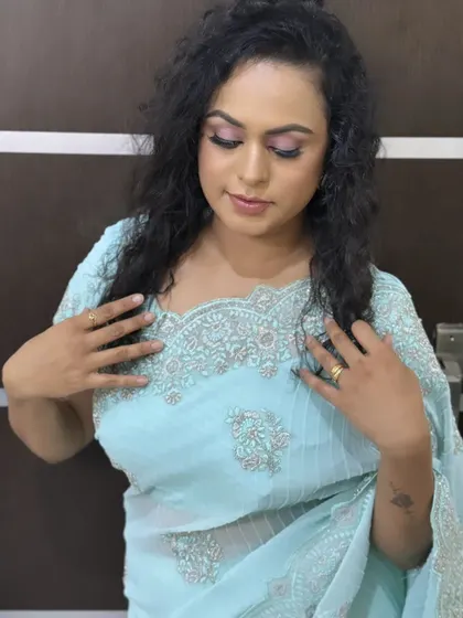 A glamorous pose showing off the curly hairstyle and soft pink smokey eye. This is a great look for a reception or evening party.