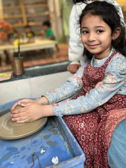 A beautiful moment of concentration and pride. This young girl is fully engaged in her pottery, showcasing the focus that our creative activities inspire.