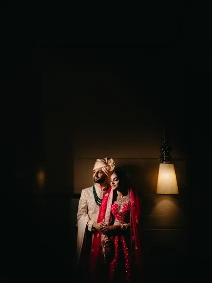 A dramatic portrait of a couple under a single lamp, using shadows and light to create a moody, cinematic feel.