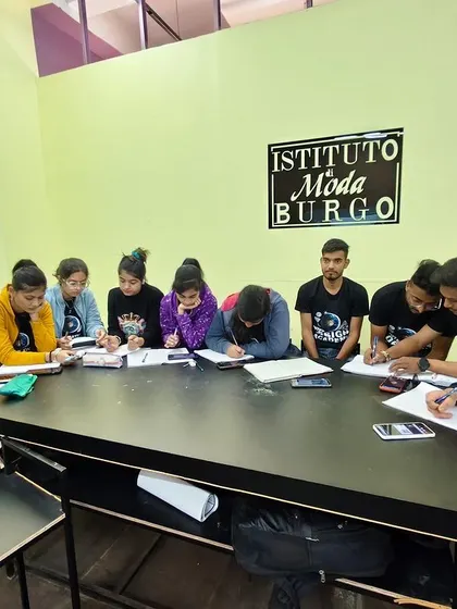 Students at Istituto Moda di Burgo fully immersed in a note-taking and drafting exercise. This is where theory turns into practical skill.