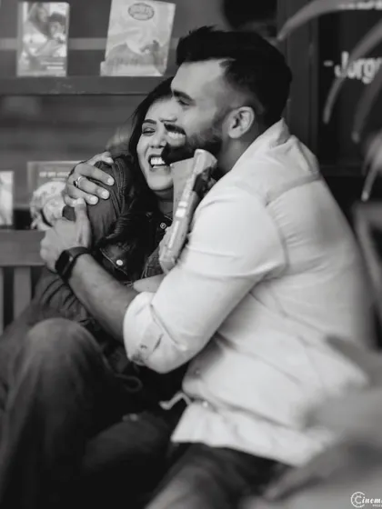 A heartfelt hug captured in a cozy, book-filled cafe. This black and white photo emphasizes the emotion and warmth of the moment, telling a story of comfort and love.
