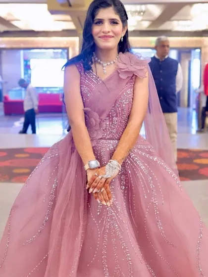A full-length view of her unique outfit. The makeup is kept simple and elegant to let the dress be the focus.
