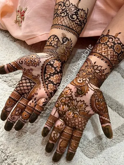 This design for a bride-to-be is a beautiful fusion of styles. It combines the elegance of peacocks with the softness of floral patterns and the intricacy of geometric jaali work.
