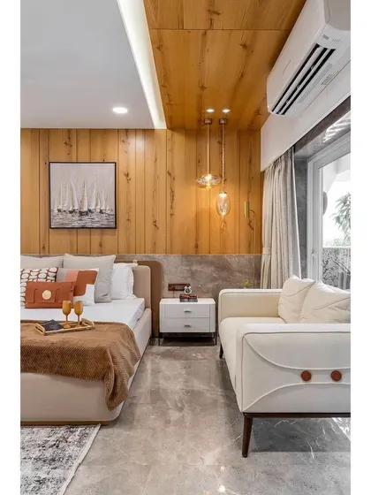 This angle shows how we can incorporate a small, comfortable seating area into a master bedroom. The design maintains a cohesive look with the wood paneling and neutral color scheme.