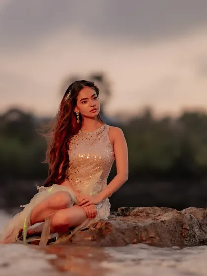 A pensive moment captured during the music video shoot. The soft lighting and natural setting complement the ethereal styling.