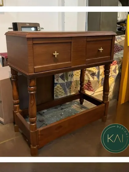 A classic wooden console table with turned legs and brass hardware, pictured in our workshop. This piece showcases our skill in traditional woodworking and finishing.