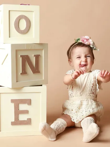 A cheeky little tongue-out expression from the birthday girl. Her personality shines in this fun first birthday portrait.