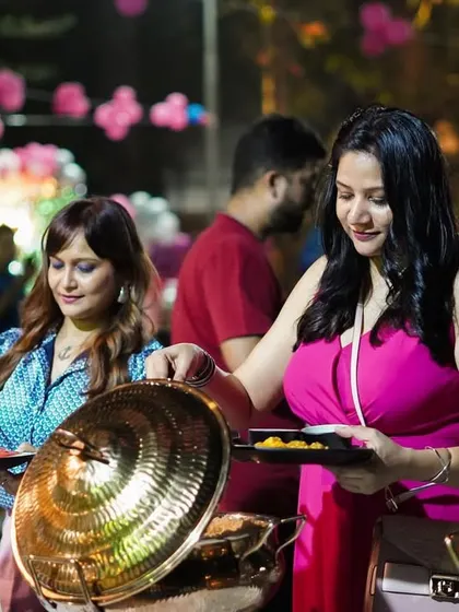Guests enjoying the buffet at an outdoor birthday party. We love seeing people delight in the food we've prepared, creating a warm and happy atmosphere for any celebration.
