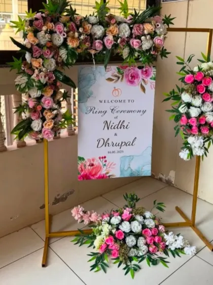 A personalized welcome sign for the ring ceremony, decorated with flowers that match the stage decor.