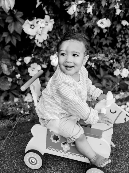 A playful moment on a rocking horse, captured in a striking black and white. This style gives a nostalgic feel to photos of classic childhood toys and games.