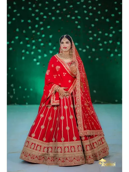 A full-length portrait of the bride in her classic red lehenga.