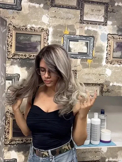 A beautiful shot of a client's new ash blonde hair against the salon's art wall.