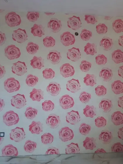 A wall covered in a repeating pink rose pattern. This classic floral design is perfect for a romantic and feminine touch.