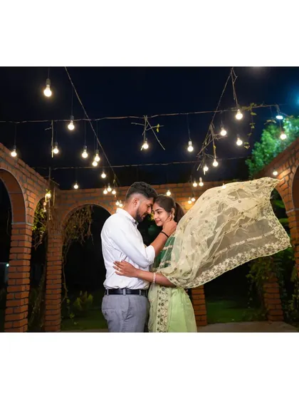 A duplicate of ID 13, showcasing a couple's intimate moment under festive string lights. The movement in the bride's veil adds a dynamic and ethereal quality.