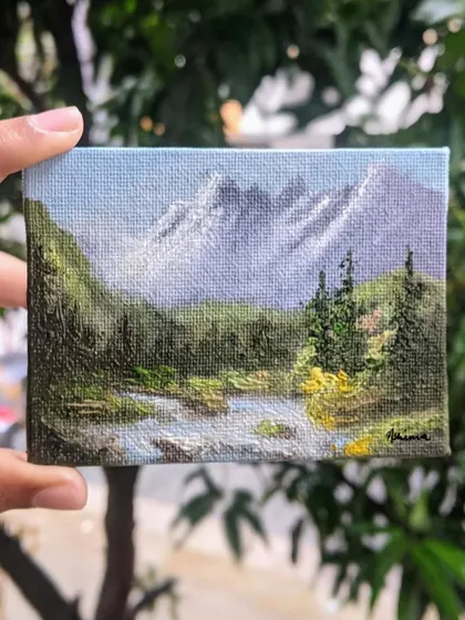 Holding this 3x4 inch canvas lets you see the details up close. I used different shades of green to paint the forest and added texture to the water to make this miniature landscape feel alive.
