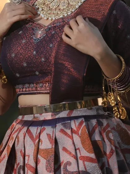 A close-up of the intricate blouse and the client's traditional bangles.