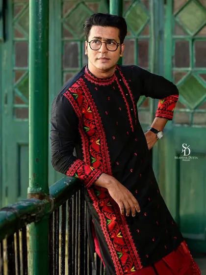 A relaxed pose from Anirban, leaning against the balcony railing. This shot captures a more casual and thoughtful side, while still highlighting the intricate embroidery of the kurta.