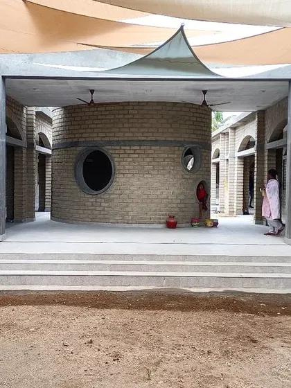 The central courtyard at Sai Kirupa Special School in Tiruppur, featuring a sensory room and shaded gathering spaces under a tensile fabric roof. The architecture is designed to be a therapeutic and engaging environment for children with special needs.